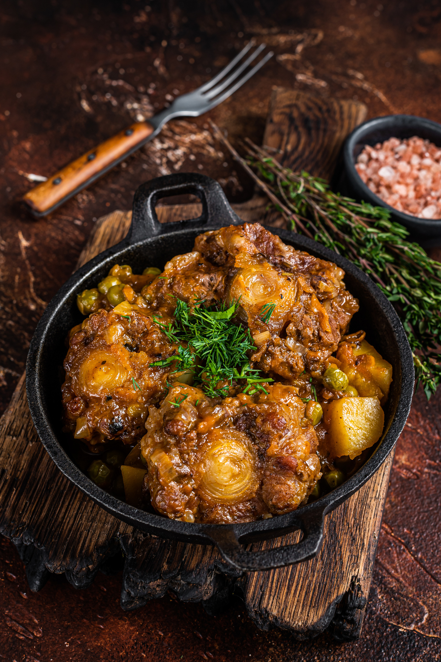 Beef Oxtails Stew with Wine and Vegetables in a Pan. Dark Background. Top View